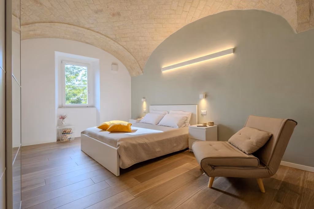 Camera da letto con letto e sedia di Corso Garibaldi 21 Apartment & rooms nel centro di Vasto