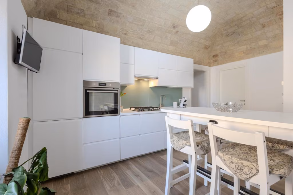 Cucina con mobili bianchi e tavolo con sedie dell’appartamento di Corso Garibaldi 21 a Vasto